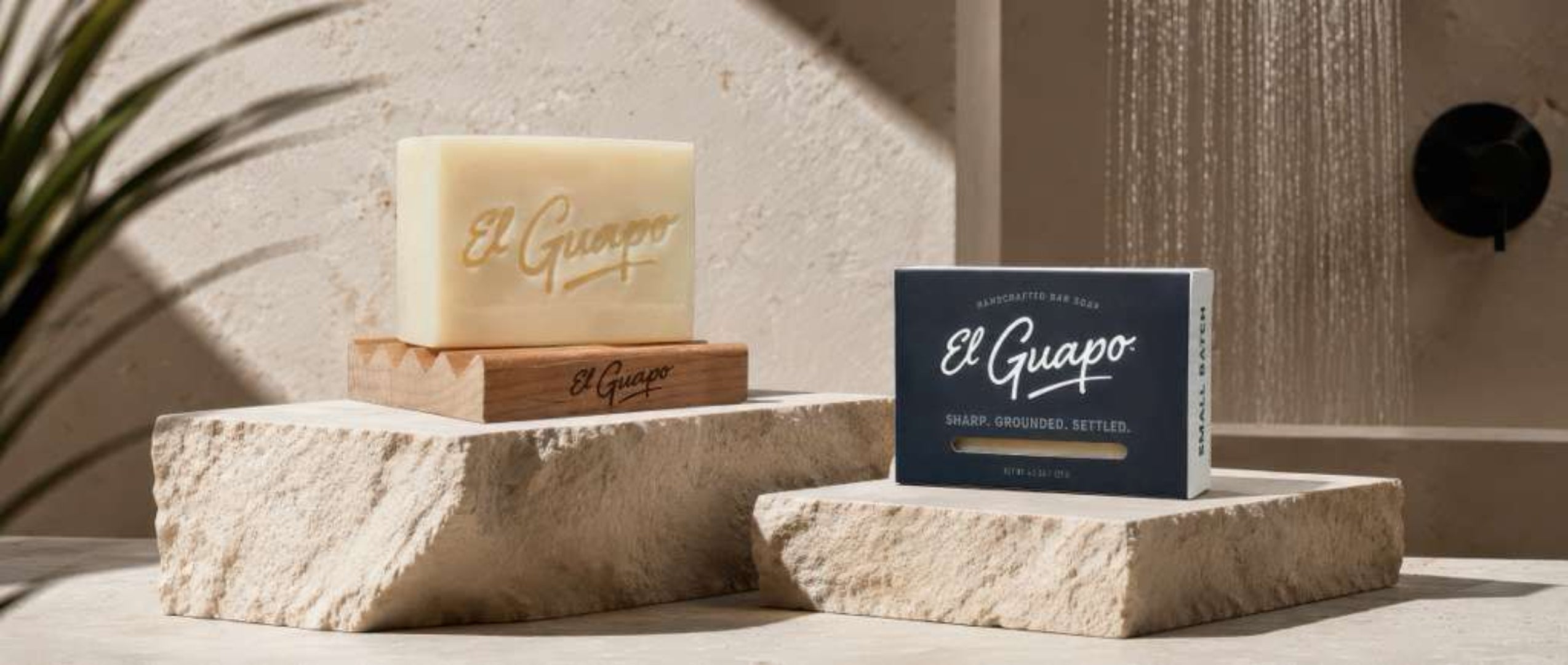 Two bars of soap with 'El Guapo' branding on stone blocks against a neutral background.